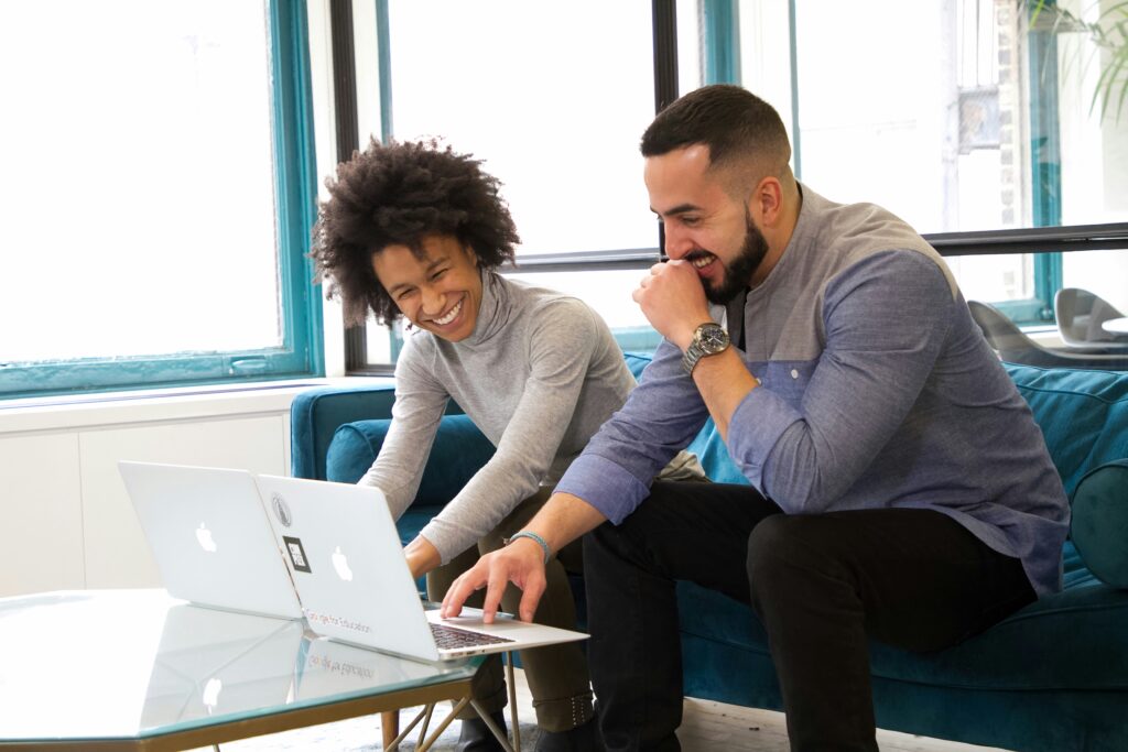 smiling employees on their Mac computers